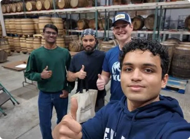 The Whiskey Library team among the barrels in a distillery warehouse