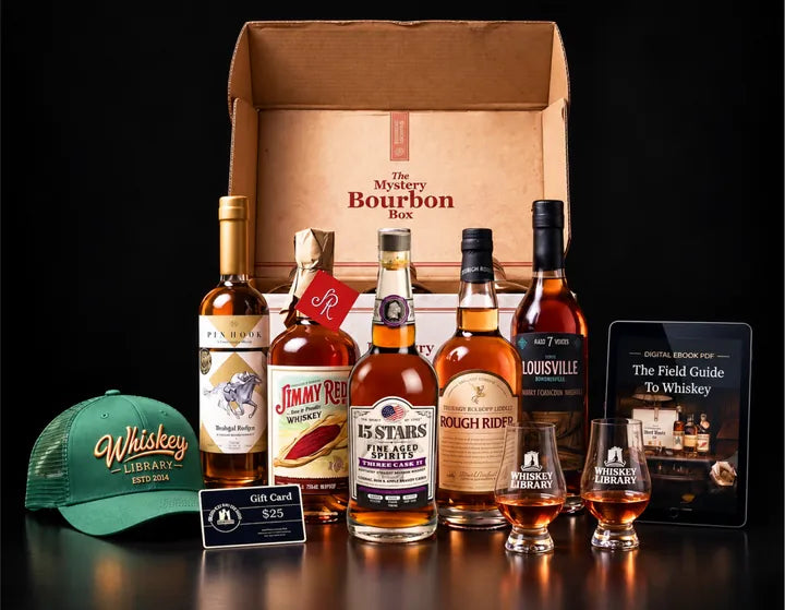 An open Bourbon Mystery Box with bottles, tasting glasses, a hat and the field guide